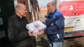 Meneer Schneider ontvangt 10 ledlampen van bezorger Marc Pasmans