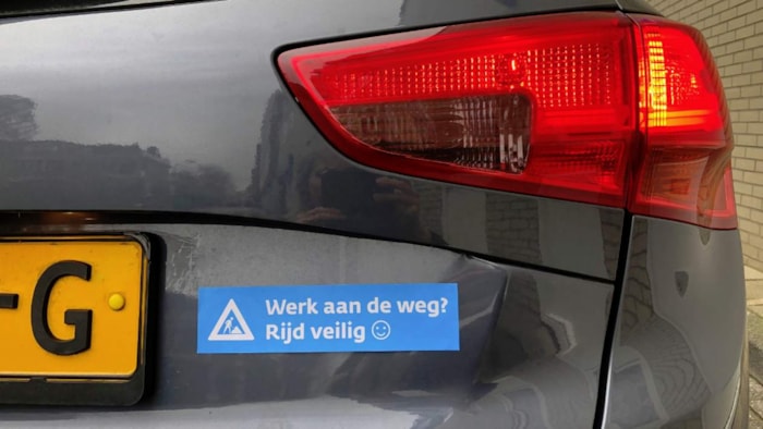 Auto met sticker Werk aan de weg Rijd veilig
