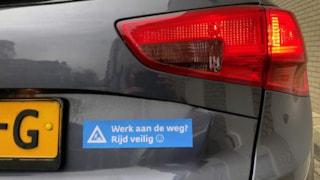 Auto met sticker Werk aan de weg Rijd veilig