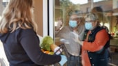 Zorgmedewerker brengt boodschappen langs tijdens coronacrisis