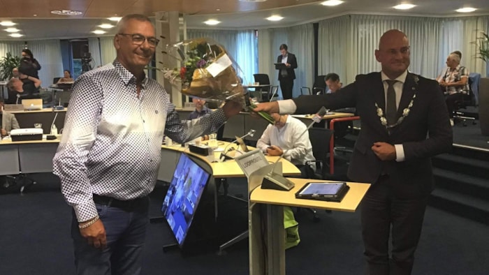Charles Webster ontvangt bloemen bij zijn installatie als commissielid
