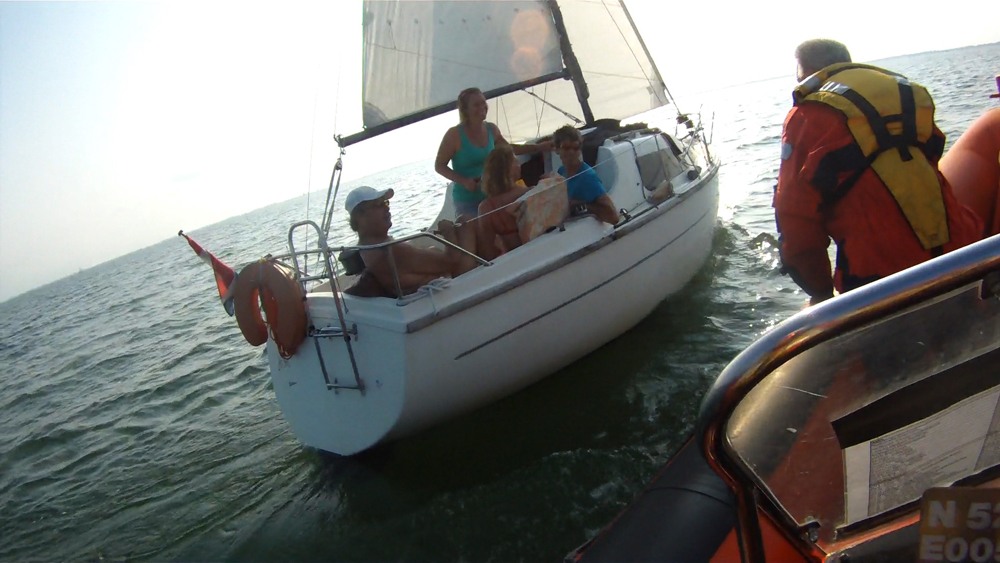 Surfer in nood gered door passerend zeiljacht