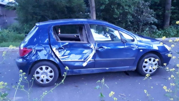De zwaar beschadigde blauwe auto