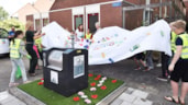 Onthulling bloementapijt bij afvalcontainer