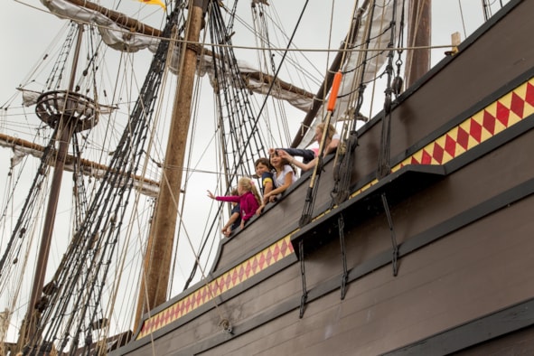 P Kinderen zwaaien vanaf de railing -Ed Post