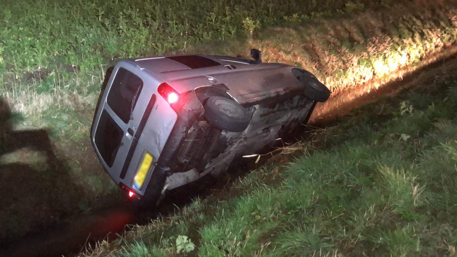 Bestelauto kantelt en raakt te water