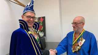 Prins Skik hangt Hendric de onderscheiding om en feliciteert hem hartelijk