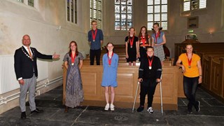 Burgemeester Nieuwenburg met de jonge helden. Boven Sander, Shiobian, Eline en Feline. Onder Marah, Julia, Sami en Cindy.