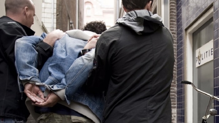 Man wordt geboeid afgevoerd