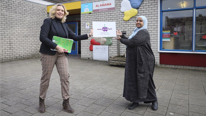 Accountmanager Rondkomen Miranda Rood overhandigt de directeur Samira van basisschool Al Amana Hoorn symbolisch het eerste lespakket