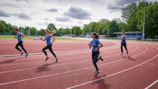 Jongeren op de atletiekbaan aan het hardlopen