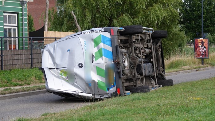 Werkbusje op zijn kant