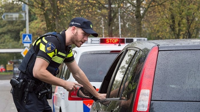 Agent spreekt automobilist bij verkeerscontrole