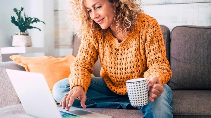 Vrouw op bank met laptop