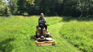 Marijcke Faas op zitmaaier in De Verteltuin