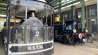 De oudste stoomtram van Nederland naast locomotief Bello in de restauratiewerkplaats